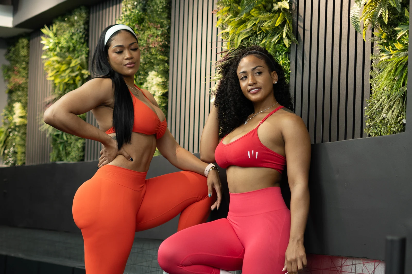 Twee leden van Savage Elite Fitness bij de groene wand in de loungeruimte