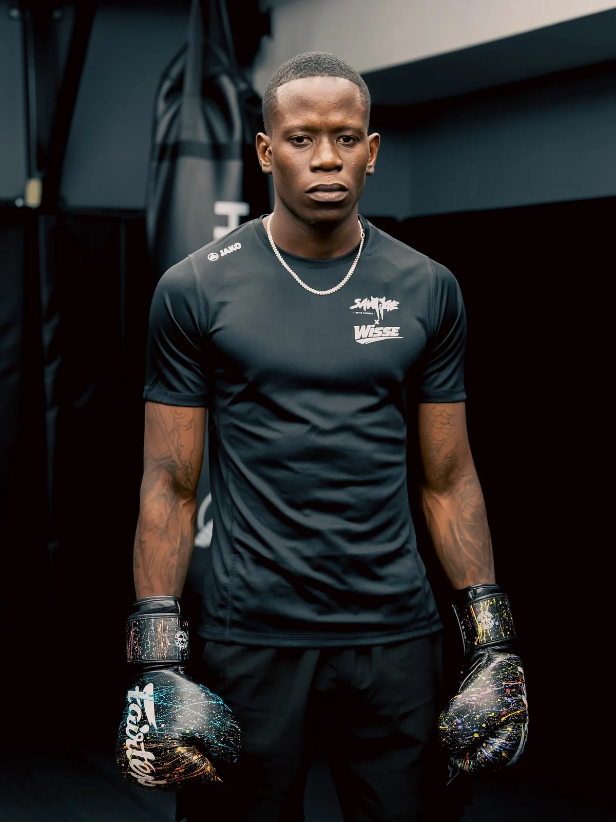 Savage boxer standing in gloves beside the heavy bag