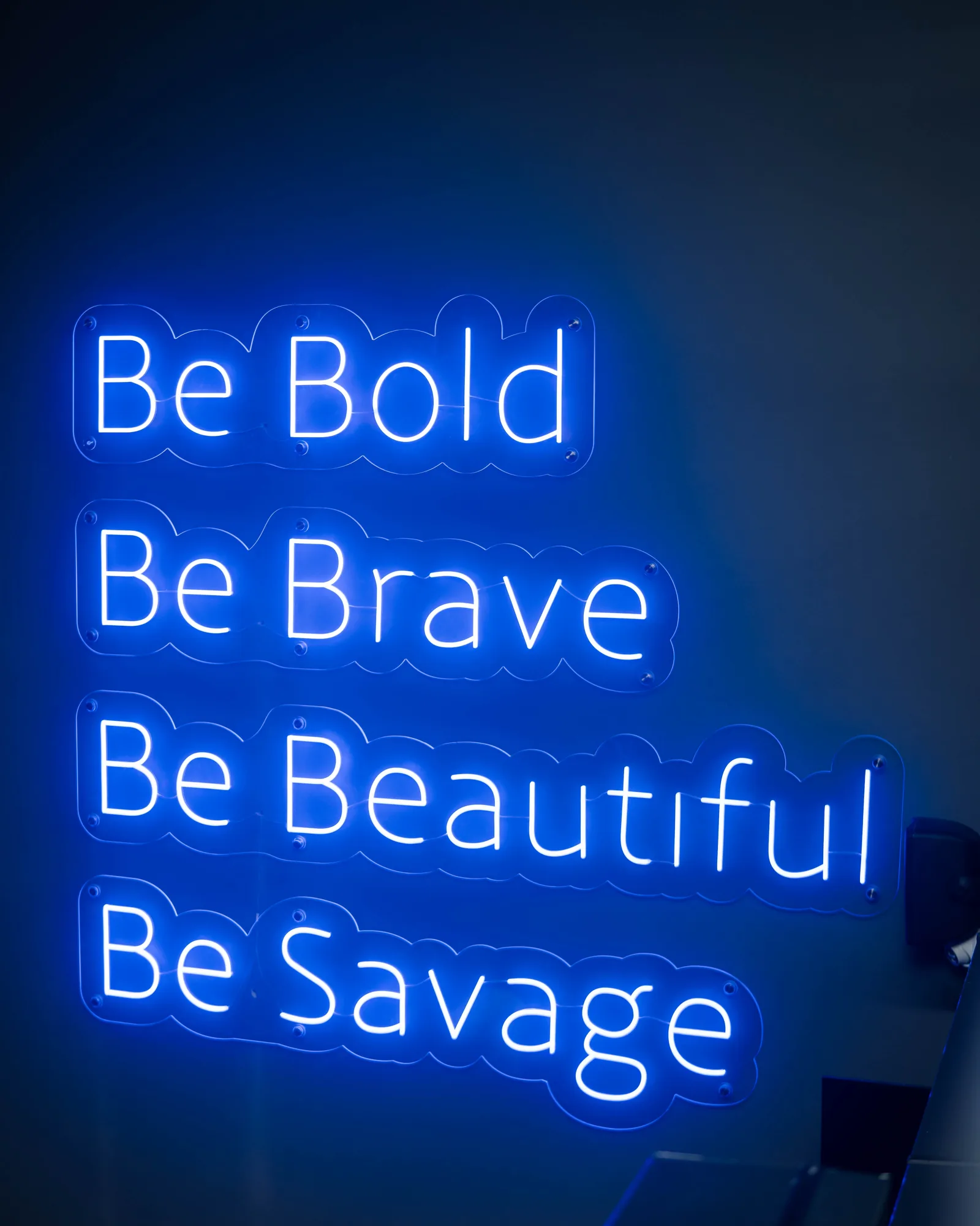 Neon sign reading Be Bold, Be Brave, Be Beautiful, Be Savage